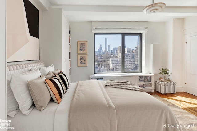 bedroom with wood finished floors and a view of skyline