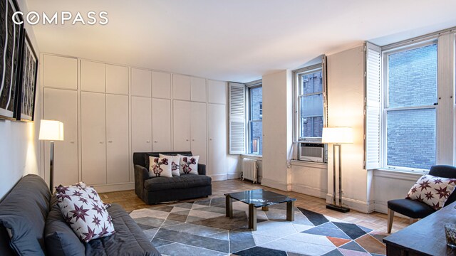 907 5th Ave Unit 4F, New York City, NY 10021 - living area with radiator heating unit, plenty of natural light, and baseboards