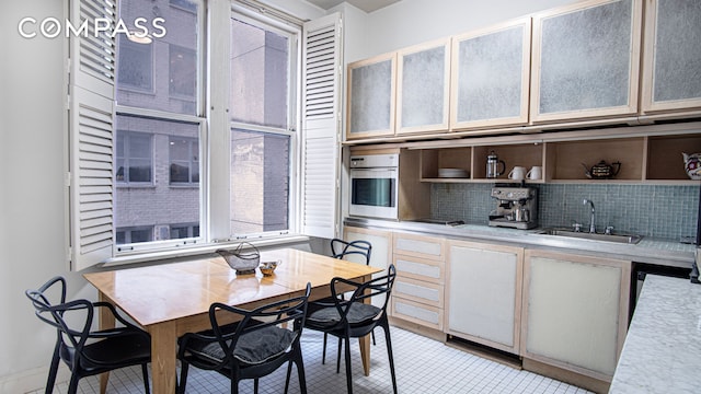 907 5th Ave Unit 4F, New York City, NY 10021 - kitchen featuring a sink, open shelves, light countertops, backsplash, and stainless steel oven