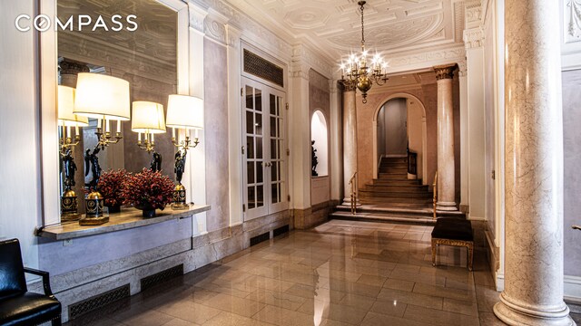 907 5th Ave Unit 4F, New York City, NY 10021 - corridor featuring a chandelier, arched walkways, an ornate ceiling, and stairway