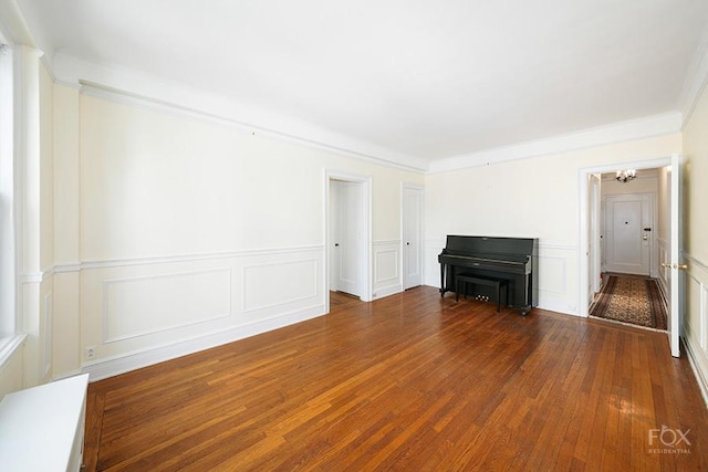 255 W End Ave Unit 12C, New York City, NY 10023 - unfurnished living room featuring a decorative wall, wood finished floors, a wainscoted wall, and a chandelier
