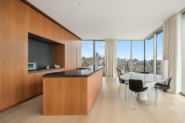 bedroom featuring a view of city lights and wood finished floors