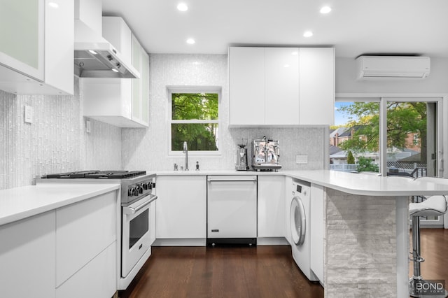 82-15 Penelope Ave, New York City, NY 11379 - kitchen with wall chimney range hood, dishwasher, a wall mounted AC, stainless steel stove, and washer / clothes dryer