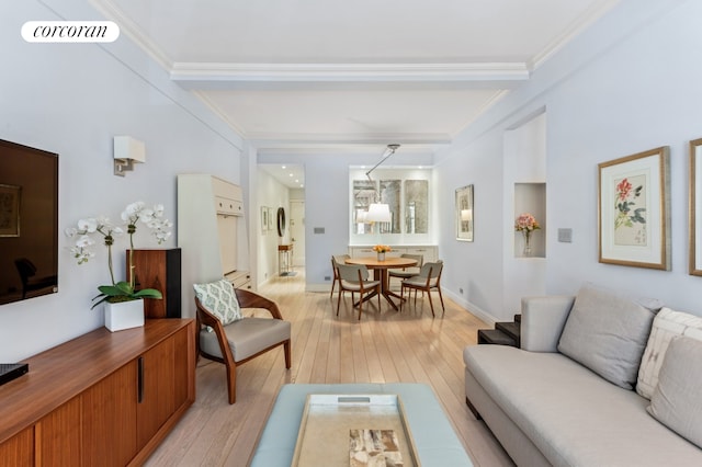 living area with light wood-type flooring, ornamental molding, baseboards, and beam ceiling