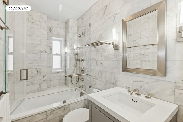 bathroom with tile walls, tiled shower / bath, vanity, and toilet