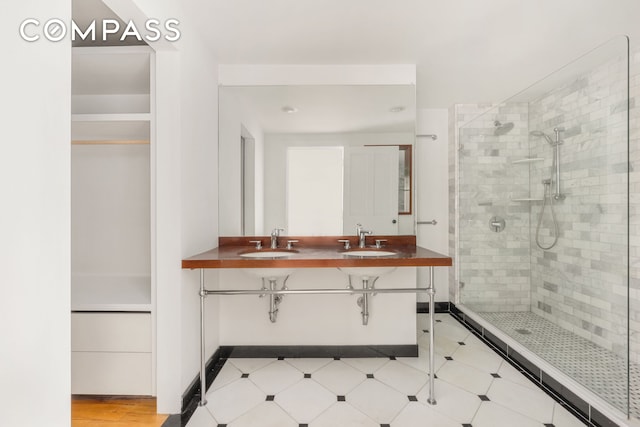 bathroom featuring a shower stall and double vanity