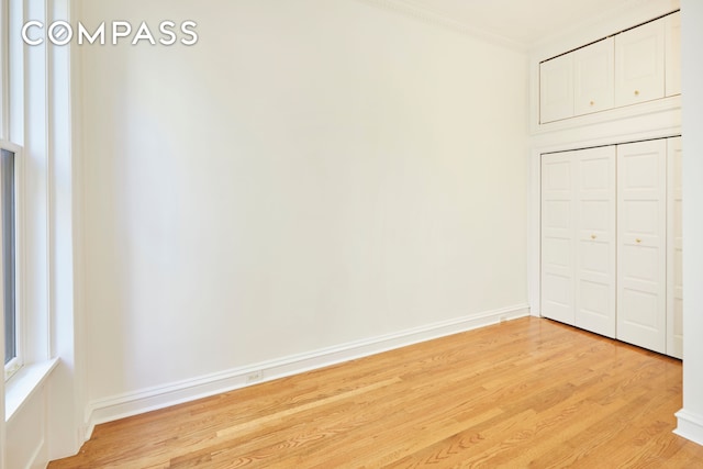 157 E 75th St Unit 1E, New York City, NY 10021 - unfurnished bedroom with light wood-type flooring, ornamental molding, baseboards, and a closet