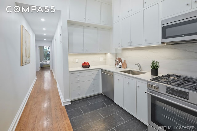 157 E 75th St Unit 1E, New York City, NY 10021 - kitchen featuring stainless steel appliances, light countertops, tasteful backsplash, white cabinets, and recessed lighting