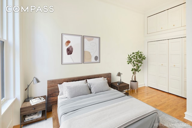 157 E 75th St Unit 1E, New York City, NY 10021 - bedroom with light wood-type flooring, ornamental molding, and a closet