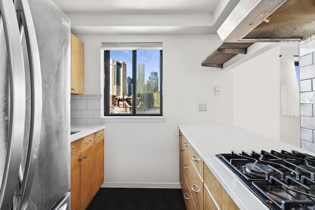 kitchen with freestanding refrigerator, black gas stovetop, light countertops, tasteful backsplash, and brown cabinets