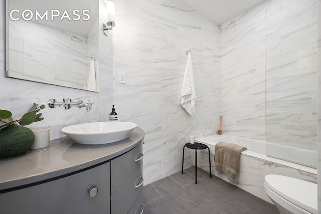 full bathroom featuring tile walls, vanity, and toilet