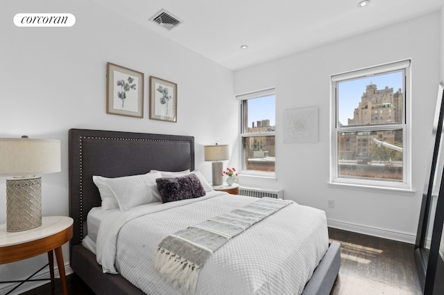 bedroom featuring dark wood finished floors, baseboards, recessed lighting, and radiator heating unit