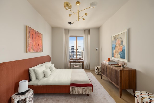 bedroom featuring a chandelier, wood finished floors, and a city view