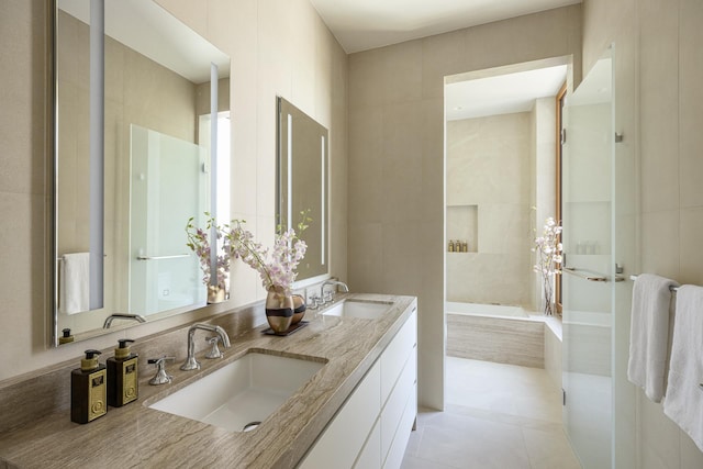 full bathroom with tiled bath, tile patterned flooring, and double vanity