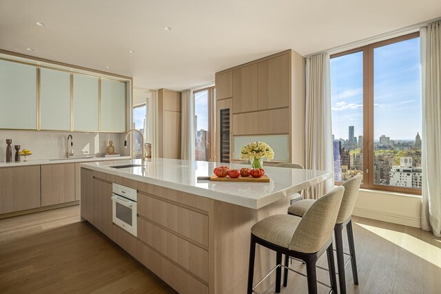 kitchen featuring a sink, modern cabinets, oven, and light brown cabinetry