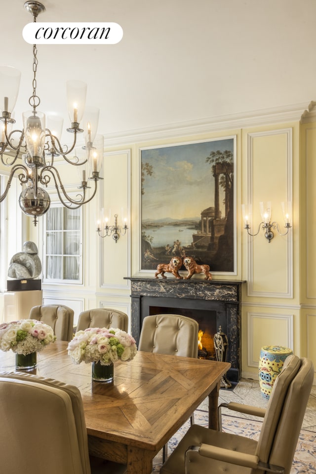dining room featuring a chandelier, a decorative wall, and a high end fireplace