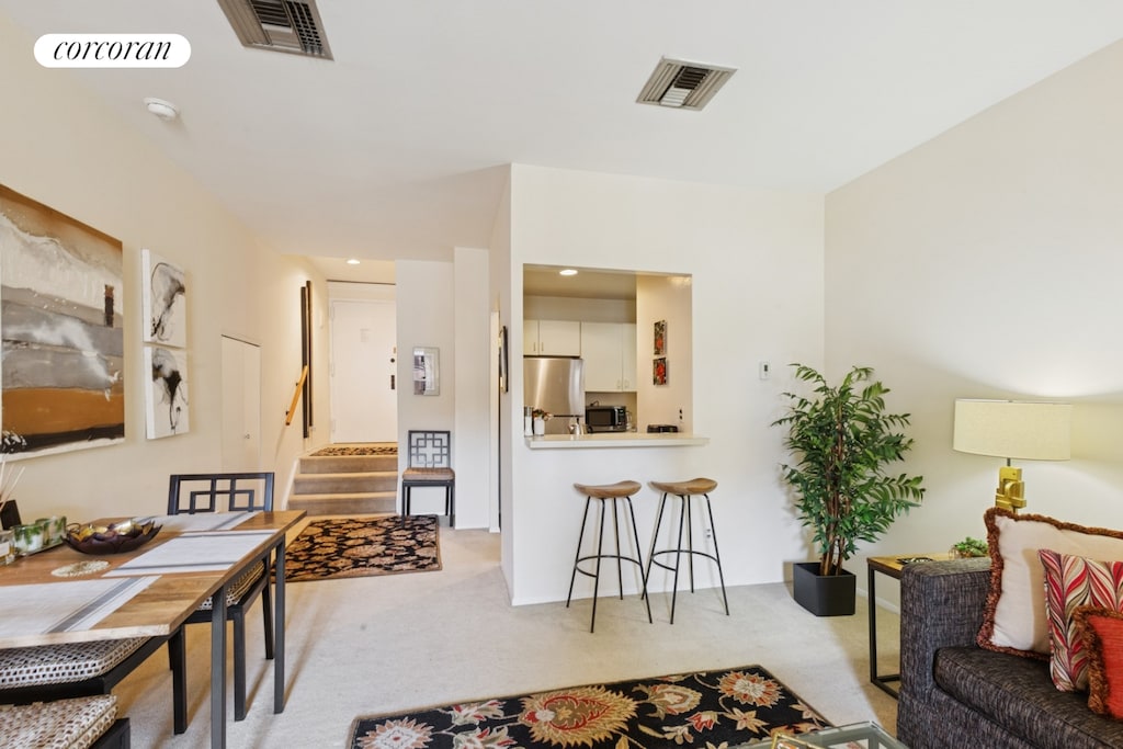 living area with carpet and stairway