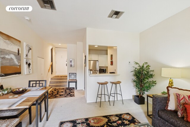 living area with carpet and stairway