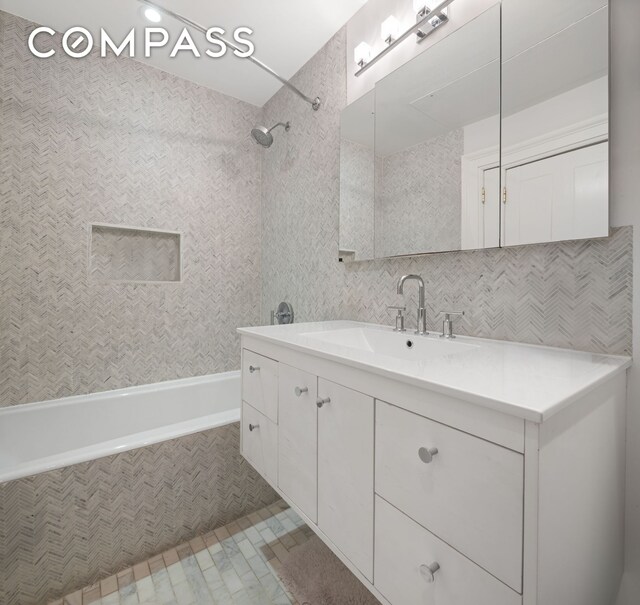 full bathroom featuring tiled shower / bath combo and vanity