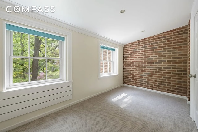 carpeted empty room with brick wall, baseboards, and radiator