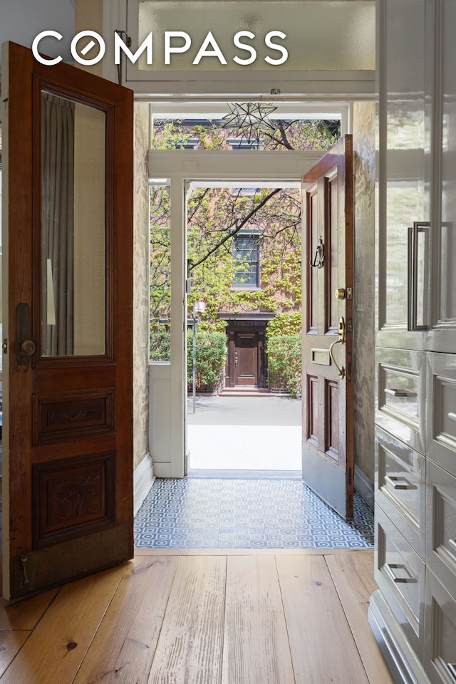 doorway featuring light wood-style floors and baseboards