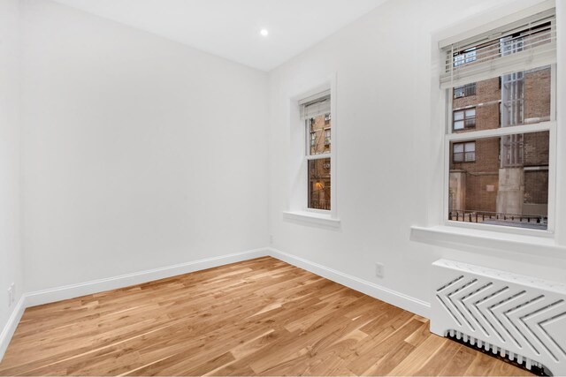 634 E 14th St Unit 4, New York City, NY 10009 - spare room with baseboards, light wood-type flooring, recessed lighting, and radiator heating unit