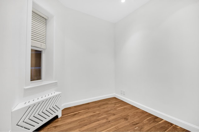 unfurnished room featuring wood finished floors, baseboards, and recessed lighting