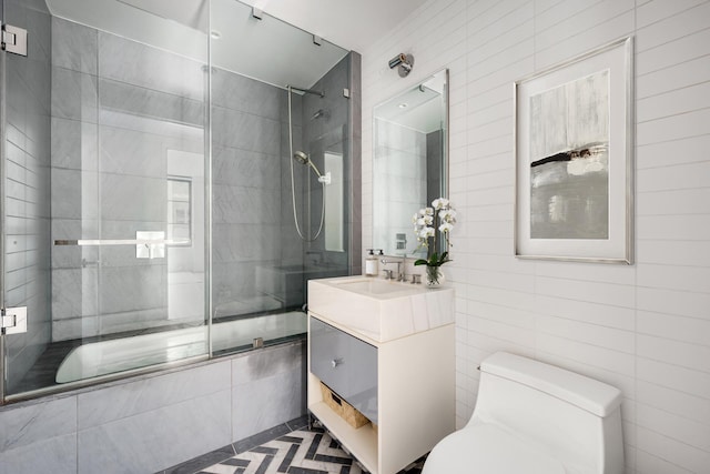 full bathroom featuring tile walls, toilet, vanity, and tiled shower / bath