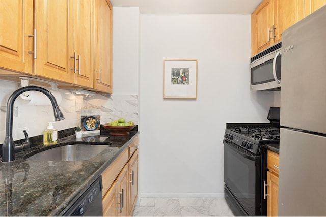 kitchen with freestanding refrigerator, stainless steel microwave, black gas range oven, a sink, and light marble finish flooring