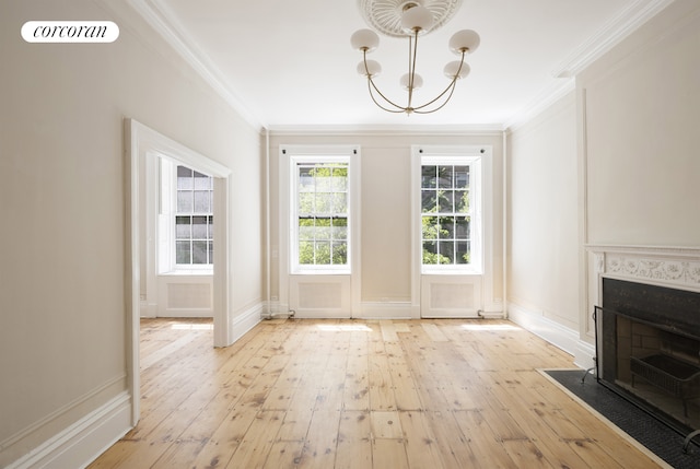 3 E 9th St, New York City, NY 10003 - unfurnished dining area featuring crown molding, light wood-style flooring, a fireplace with flush hearth, baseboards, and a chandelier