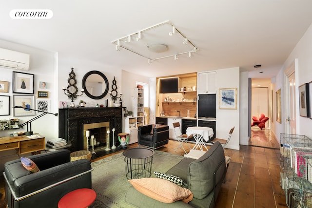 3 E 9th St, New York City, NY 10003 - living room featuring dark wood-type flooring, a fireplace, a wall mounted AC, and track lighting
