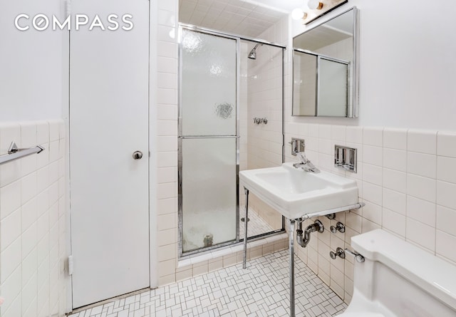 bathroom featuring tile walls, a shower stall, and toilet