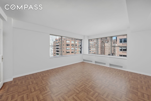 spare room with baseboards and a city view