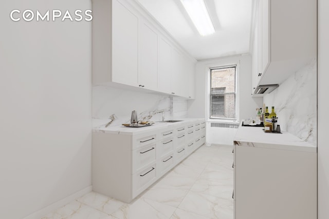 43-08 41st St Unit 5D, New York City, NY 11104 - bar featuring light marble finish floors, a sink, radiator, and decorative backsplash