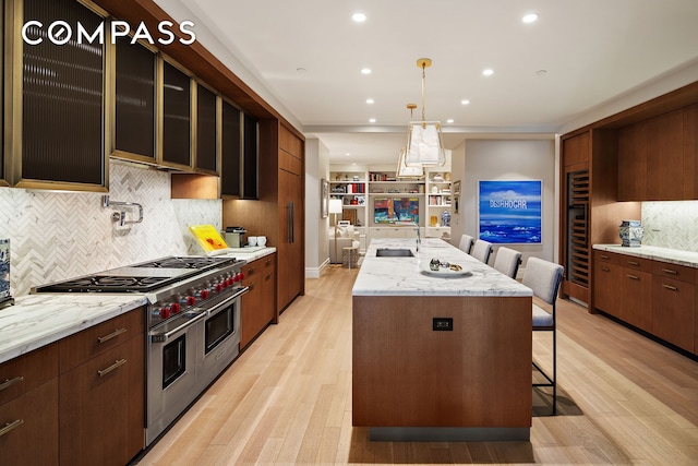 100 Barclay St Unit 20D, New York City, NY 10007 - kitchen with range with two ovens, a sink, a kitchen island with sink, backsplash, and beverage cooler