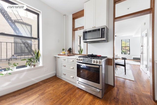 157 Kane St Unit 3, New York City, NY 11231 - kitchen featuring stainless steel appliances, dark wood-style flooring, white cabinetry, and baseboards