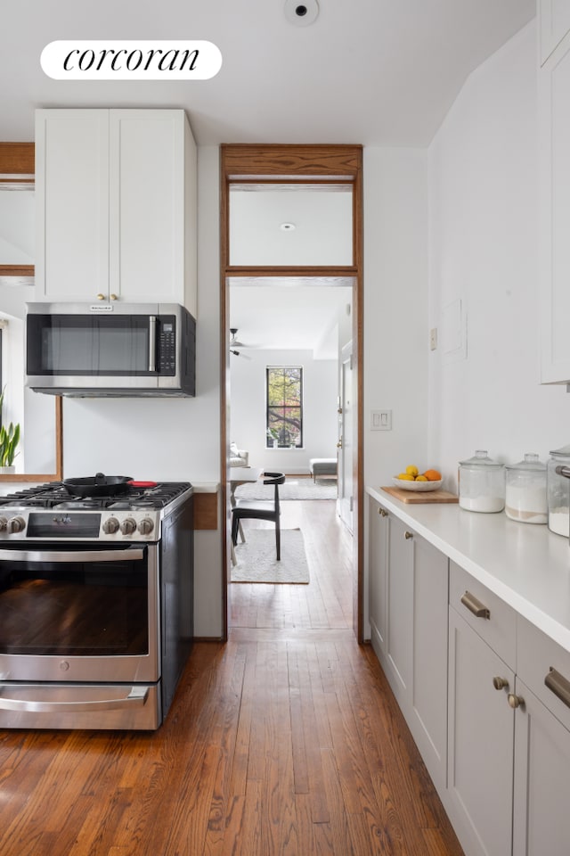 157 Kane St Unit 3, New York City, NY 11231 - kitchen with appliances with stainless steel finishes, dark wood finished floors, light countertops, and white cabinetry