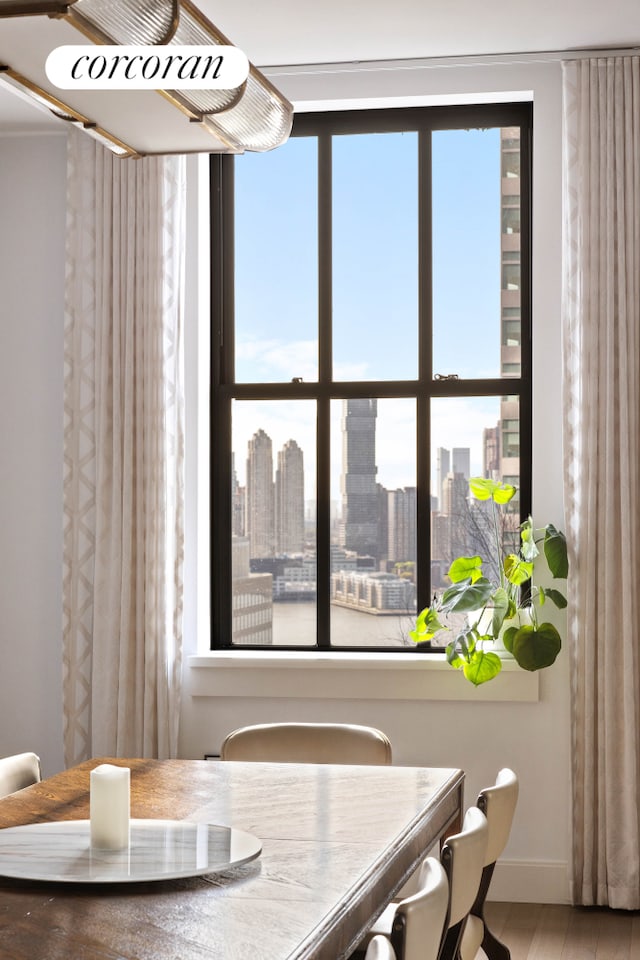 100 Barclay St Unit 20B, New York City, NY 10007 - dining space with baseboards, a city view, and wood finished floors