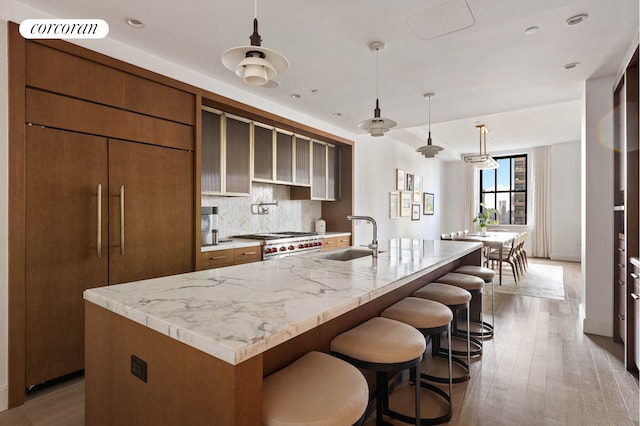 100 Barclay St Unit 20B, New York City, NY 10007 - kitchen featuring a sink, brown cabinetry, tasteful backsplash, stove, and recessed lighting