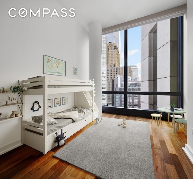 101 Warren St Unit 11L, New York City, NY 10007 - bedroom featuring a city view, wood finished floors, and a wall of windows