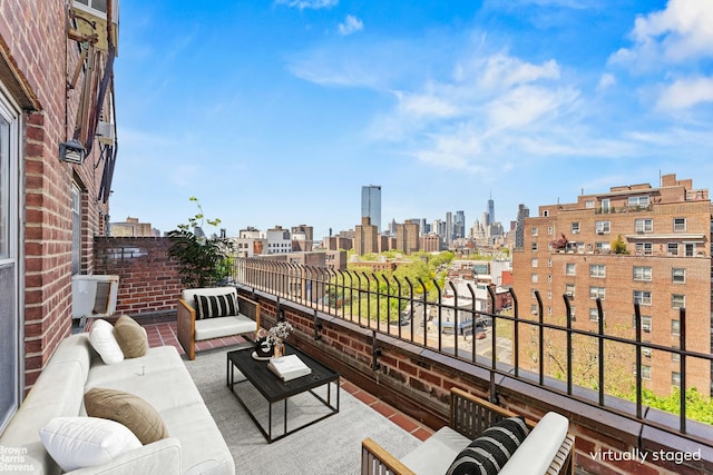 balcony with a view of skyline, central air condition unit, and outdoor lounge area
