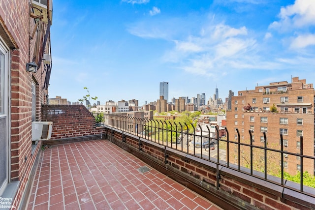 view of patio featuring a balcony, a skyline view, and central air condition unit