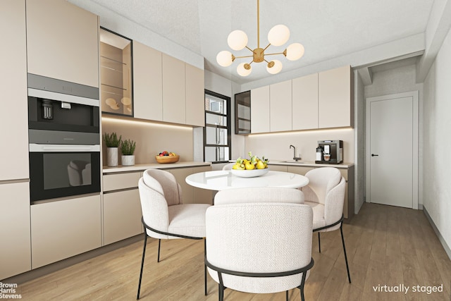 550 Grand St Unit G11D, New York City, NY 10002 - kitchen with a sink, light countertops, light wood-style flooring, a chandelier, and pendant lighting