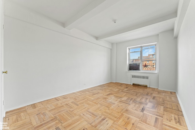 spare room featuring radiator heating unit, beam ceiling, and baseboards