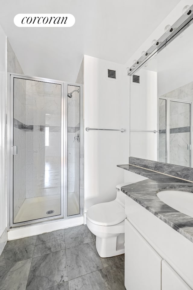 full bathroom with a shower stall, toilet, and vanity