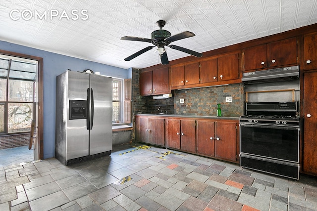 kitchen with black range with gas stovetop, stainless steel fridge with ice dispenser, under cabinet range hood, ceiling fan, and decorative backsplash