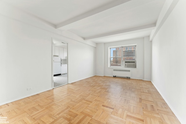 spare room featuring radiator, baseboards, beam ceiling, and cooling unit
