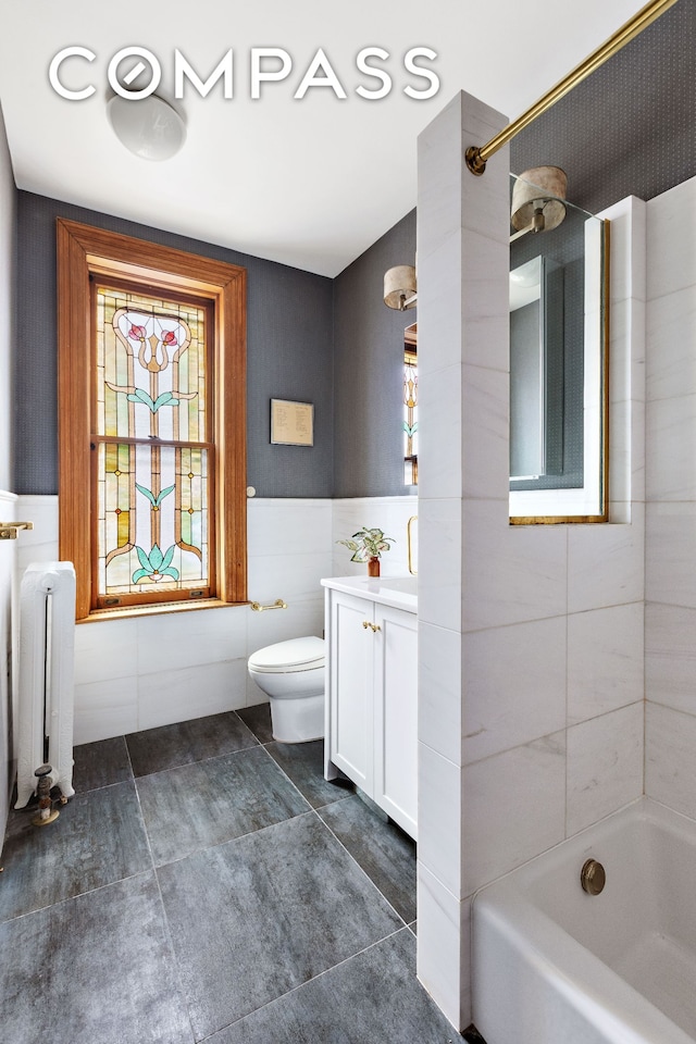 623 2nd St, New York City, NY 11215 - bathroom with radiator, vanity, toilet, tile walls, and shower / tub combination