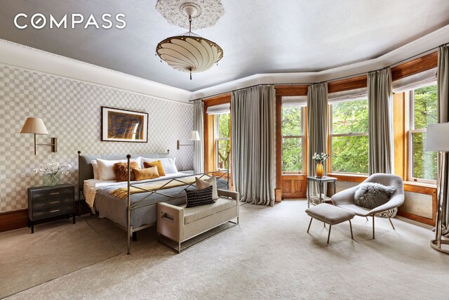 bedroom with wallpapered walls, light colored carpet, and baseboards