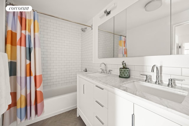 bathroom with shower / tub combo with curtain, double vanity, and backsplash